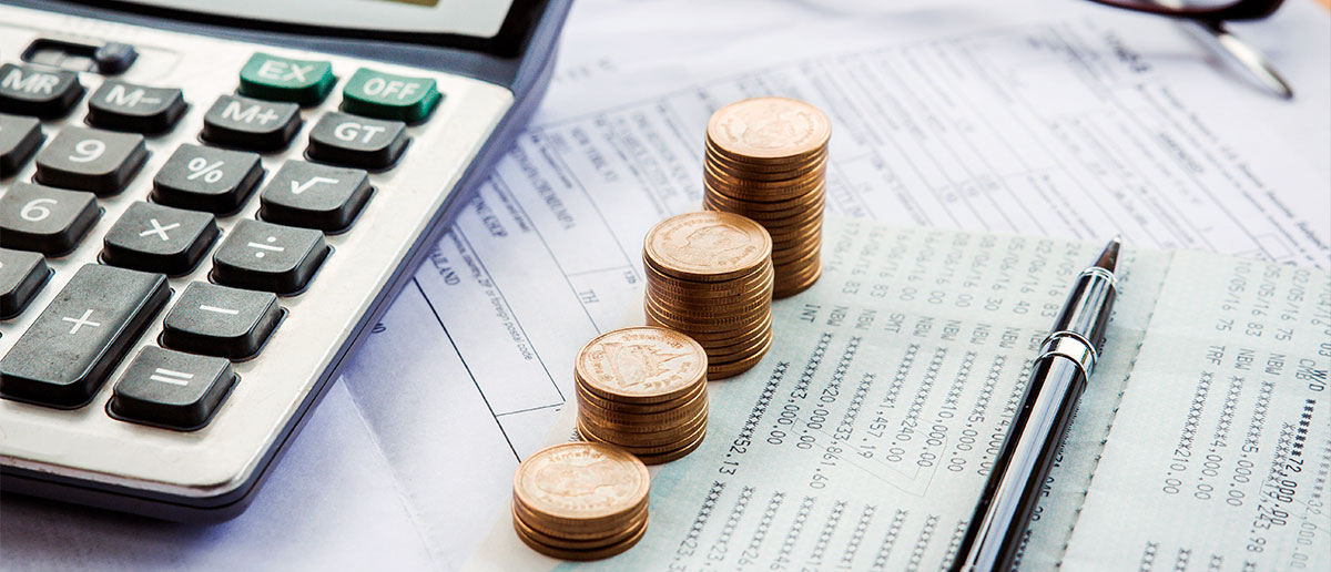 Calculadora y monedas sobre calendario fiscal