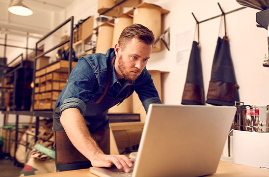 Hombre trabajando en ordenador portátil en taller